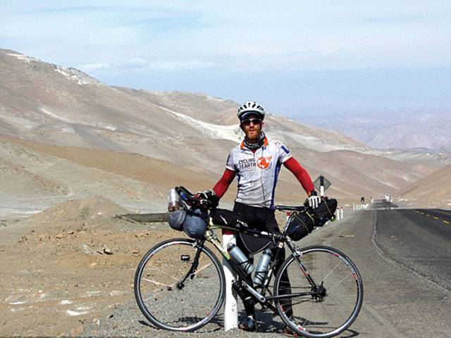 Cyclist carries mini-Olympic torch across six continents